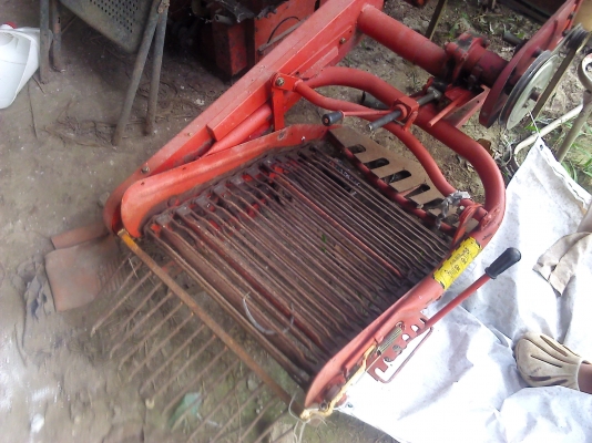 เครื่องขุดมัน ขึ้นจากดินแล้วลำเลียงตกลงบนพืน โดยไปต่อรถไถเดินตามหรือแล้วแต่