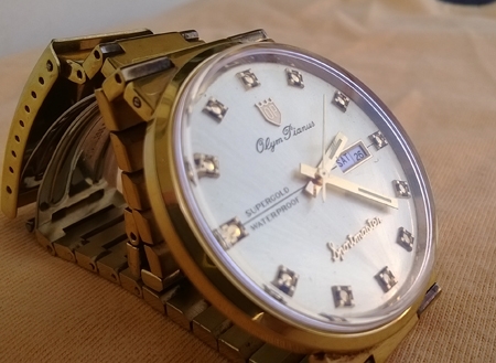 Olym Pianus Sport master  japan movt ขนาด 38มม. (รวมเข็ม) สีทอง เรือน stainless หลักดอกไม้ มีช่องบอก วัน/วันที่ อยู่หลักสาม สภาพ 95\%