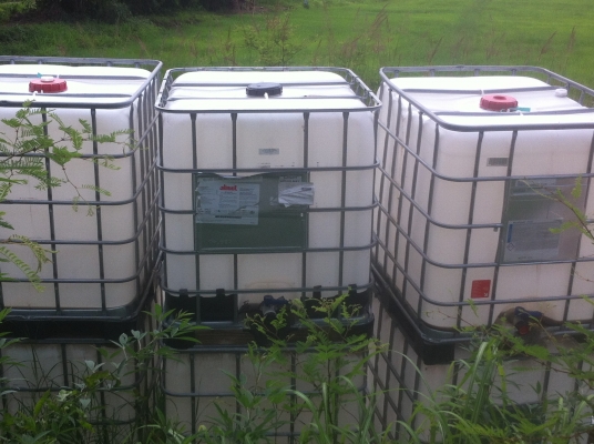 ถังพลาสติกสีเหลี่ยมขาวขนาดบรรจุ 1000 ลิตร พร้อมกรงเสริมความแข็งแรงวางบนแผ่นพาเลส