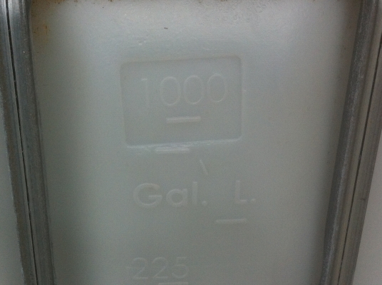 ถังพลาสติกสีเหลี่ยมขาวขนาดบรรจุ 1000 ลิตร พร้อมกรงเสริมความแข็งแรงวางบนแผ่นพาเลส