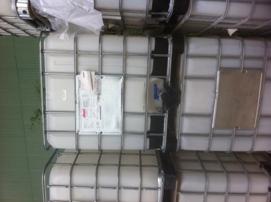 ถังพลาสติกสีเหลี่ยมขาวขนาดบรรจุ 1000 ลิตร พร้อมกรงเสริมความแข็งแรงวางบนแผ่นพาเลส